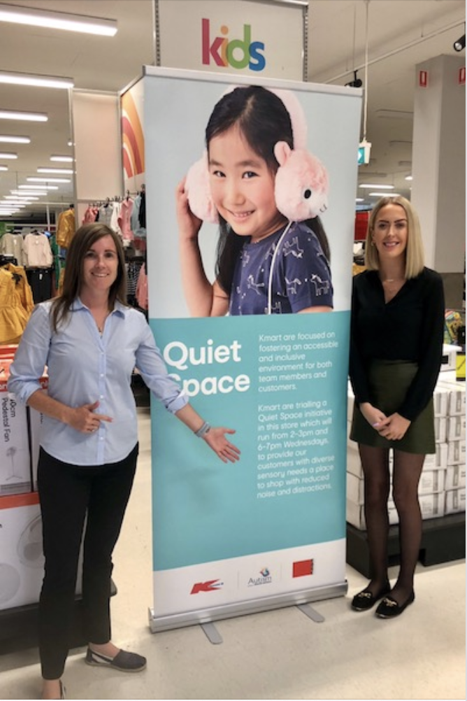 Two Edge staff members standing either side of the Kmart Quiet Space Banner in-store