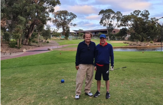 Alexendar standing beside a man on a golf green