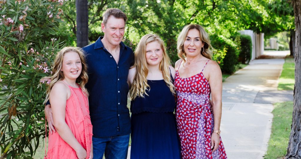 Christina standing with her two daughters and husband Paul