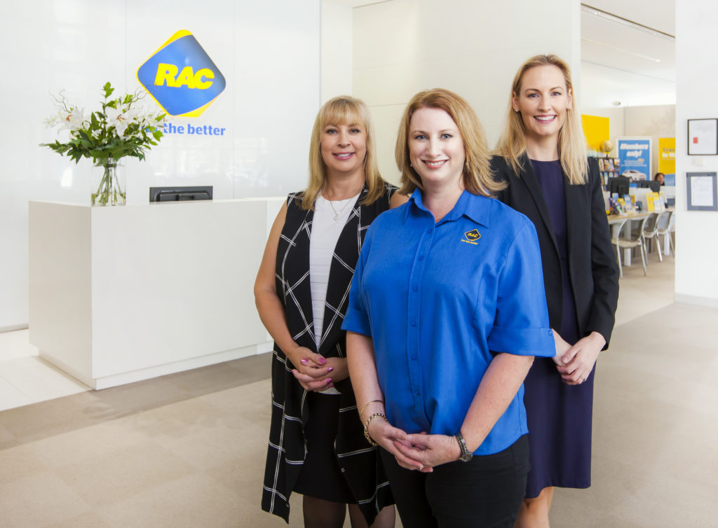 Image of three RAC staff standing in front of their reception desk