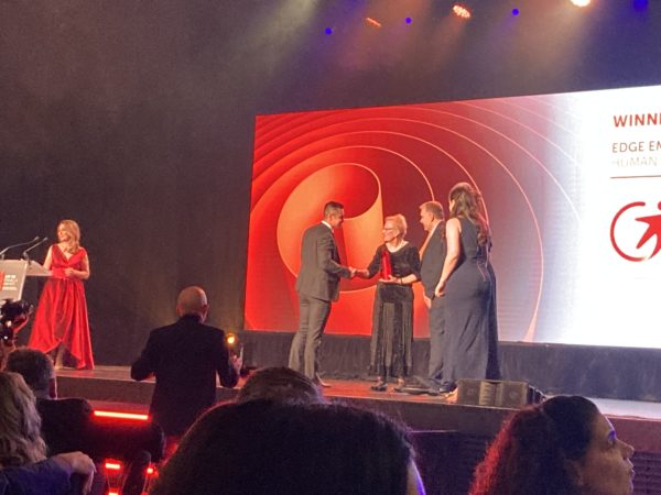 Sally shaking a mans hand while presenting him the award