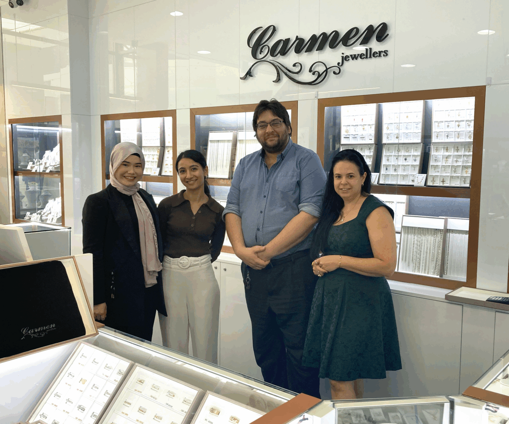 Matthew standing alongside 3 women. They are all smiling standing in a jewellery store.