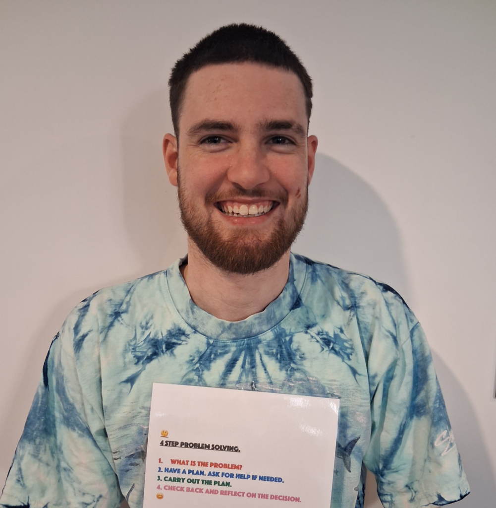Brody proudly holds a '4 Step Problem Solving' resource designed to support confidence and decision-making. The image features a red border with a grey line.