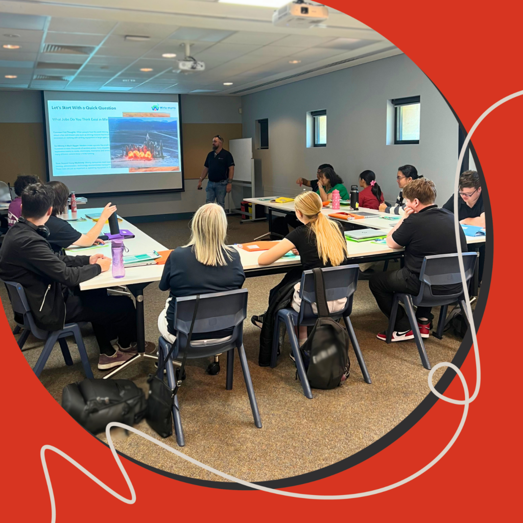 Students seated in a classroom listening to a presentation as part of Edge’s Project Employment program, with a presenter at the front and a presentation screen displaying workplace information.